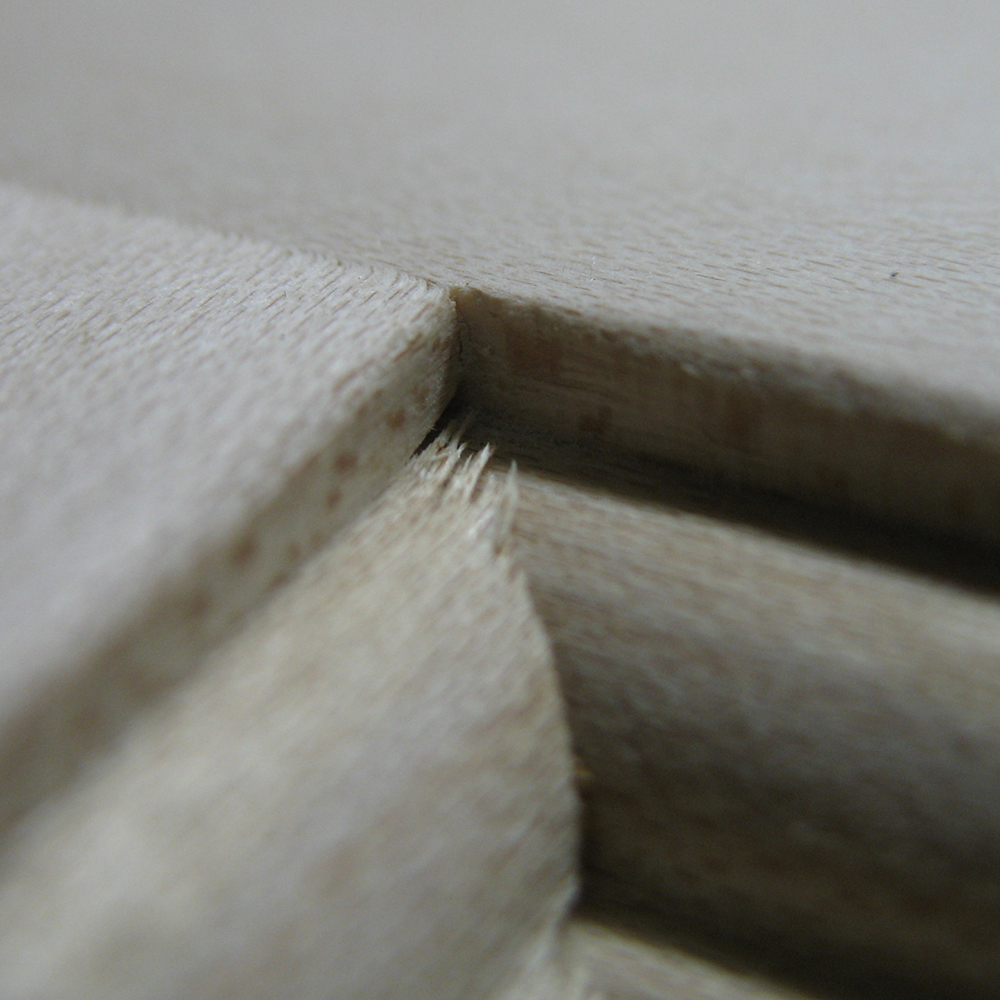 Detailed view of a mitered corner of a cabinet door with slight splintering